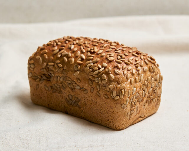 Ein Stück Bio Dinkelbrot mit Vollkorn liegt auf einem Tuch