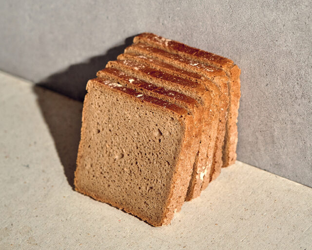 6 aufgeschnittene Scheiben vom Bio Roggen Kastenbrot lehnen an einer Wand.